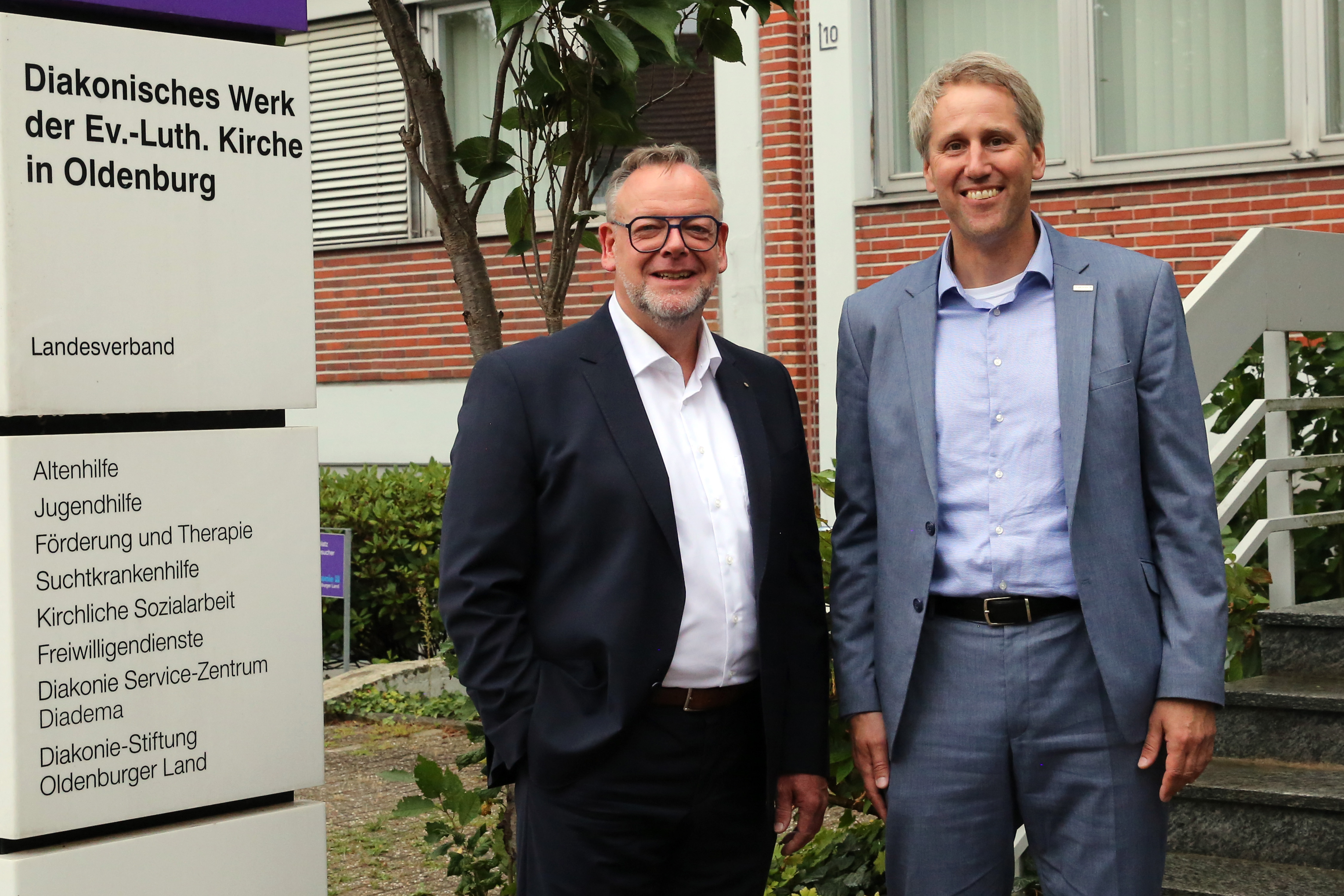 Christian Scheuer (links) und Mario Behrends stehen nebeneinander und blicken in die Kamera. Scheuer wird ab Januar 2027 Theologischer Vorstand, Behrends ist Kaufmännischer Vorstand des Diakonischen Werks im Oldenburger Land.